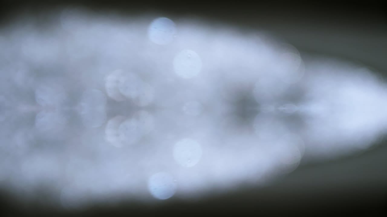 회전 슬로우 모션 및 파란색 복사 공간 배경이 있는 예술적 흐림 거품 및 점