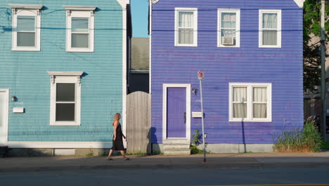 colourful homes with woman walking in front of in the morning in halifax, nova scotia