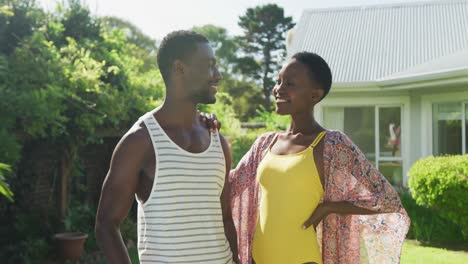 Retrato-De-Una-Feliz-Pareja-Afroamericana-En-Un-Jardín-Soleado-Sonriendo-A-La-Cámara