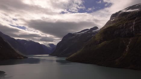 aerial of a lake surrouded by mountains in norway