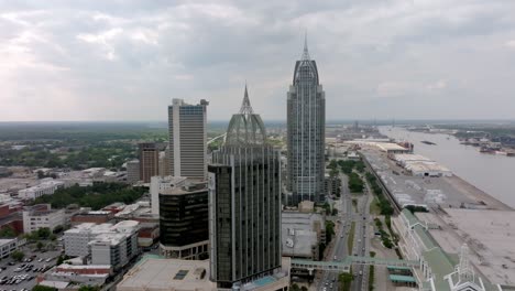 Downtown-Mobile,-Alabama-with-traffic-and-drone-video-moving-up-and-in