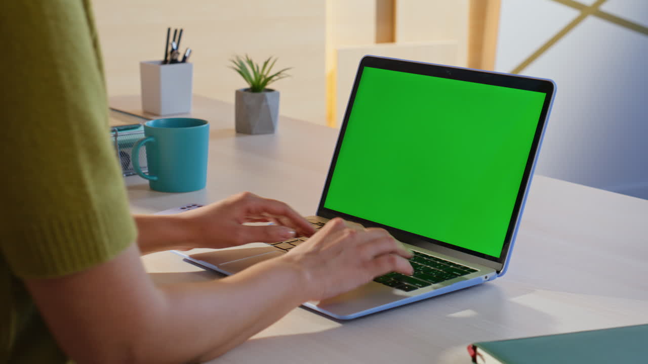 mujer trabajando en una computadora portátil con una pantalla verde