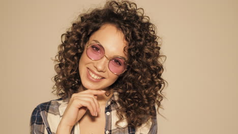 woman with curly hair and pink glasses