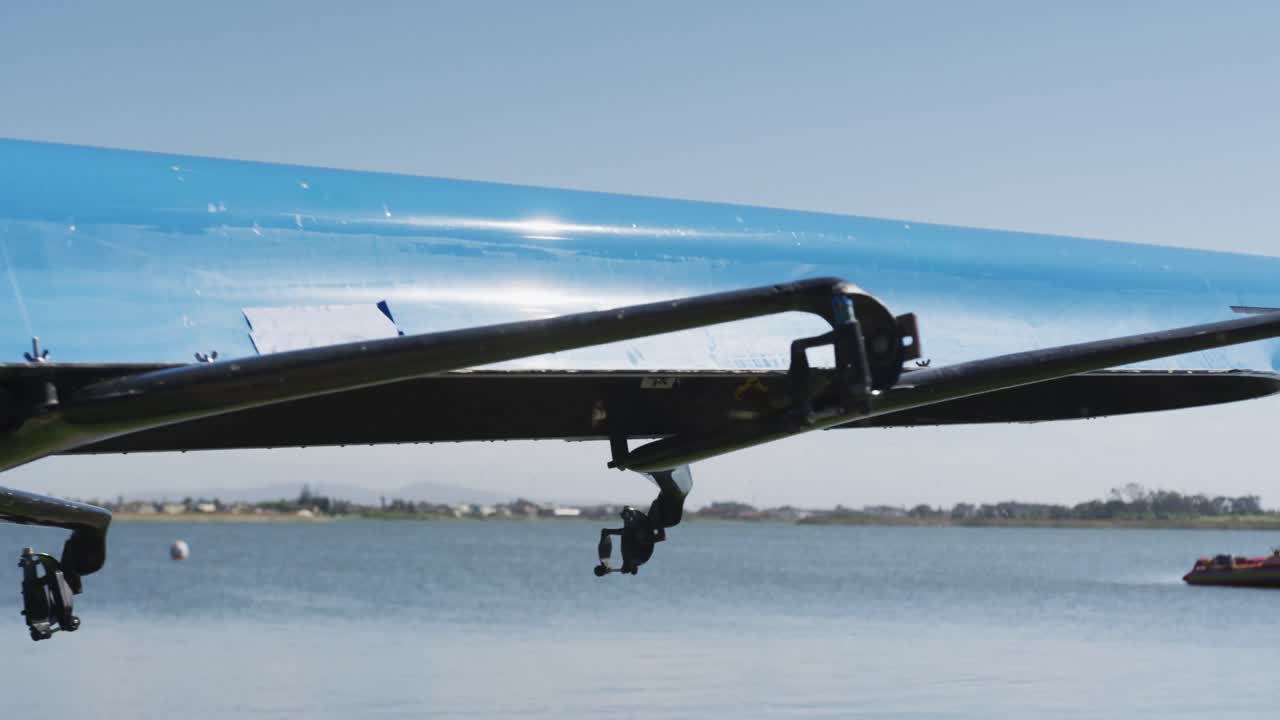 노인 백인 남성과 여성이 로잉 보트를 운반하고 있습니다.