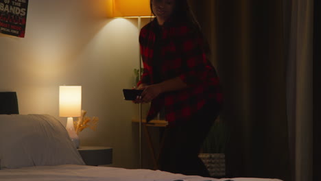 woman in bedroom using smartphone at night