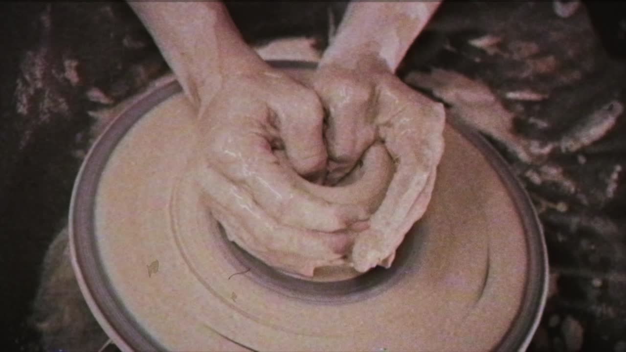 un alfarero enseña a una mujer a hacer platos de arcilla. un hombre toma las manos de una mujer. efecto vintage.