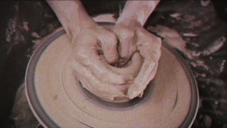 a potter teaches a woman to make clay dishes. a man takes a woman's hands. vintage effect.