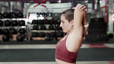 mujer estirándose en el gimnasio