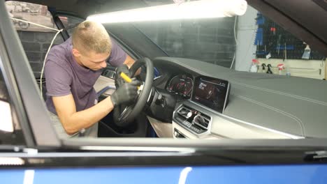 professionals repairing car engine in mechanical workshop with bright light. professionals in mechanical workshop working on car engine, tightening nut with red gloves while colleague observes, features work tools, yellow wall clock, and bright ligh