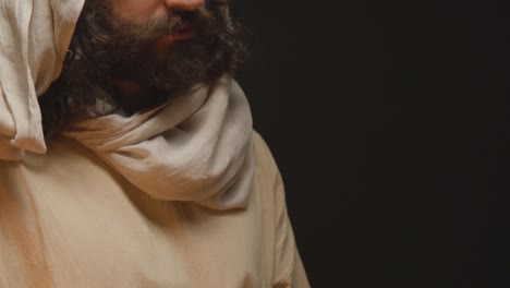 fotografía de un hombre vestido con túnicas que representan a la figura de jesucristo sosteniendo la mano de las personas para la bendición