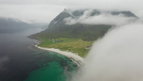 descending aerial footage of vik beach and hauklandstranda norway, coastline drone shot with turquoise blue water moving through clouds