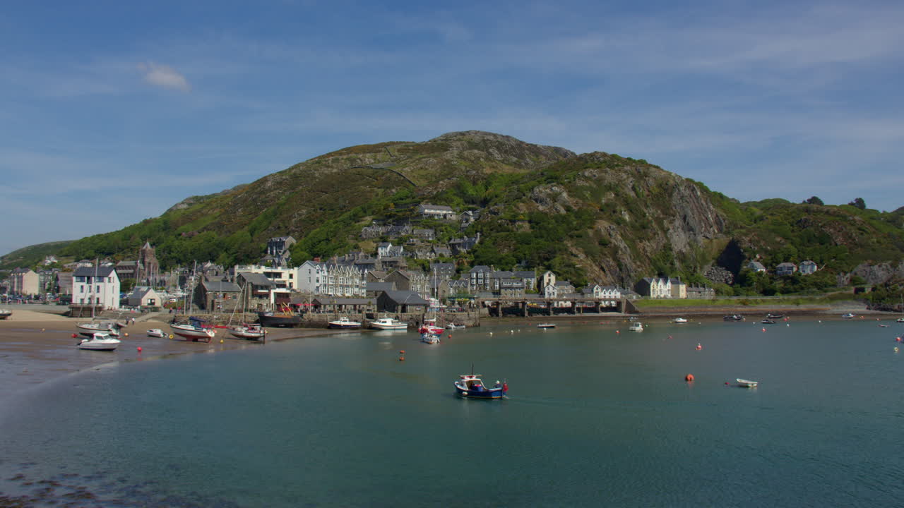 Extra wide shot of the town of Barmouth with its Harbour on the Mawddach estuary with small boat