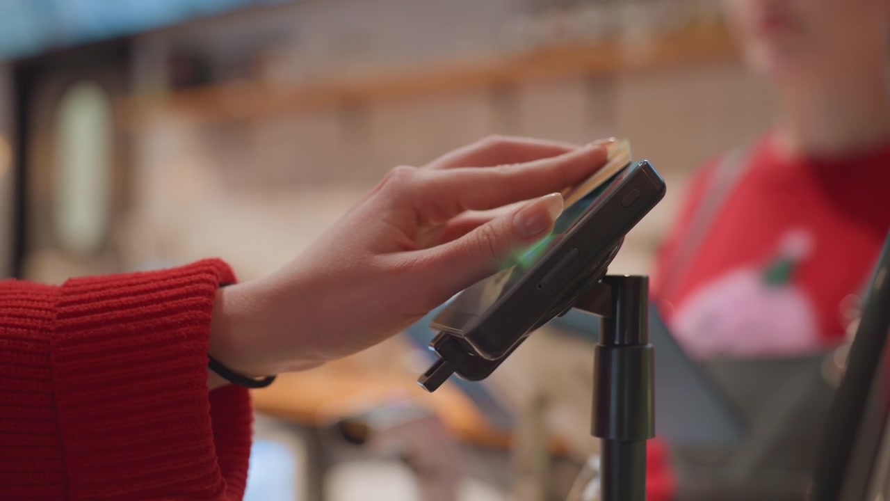 Customer Making Contactless Payment with Credit Card at POS Terminal