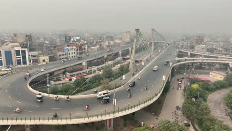 Toma-Aérea-De-Drones-Del-Movimiento-Del-Tráfico-A-Lo-Largo-Del-Puente-Azadi-En-Pakistán-Durante-La-Mañana