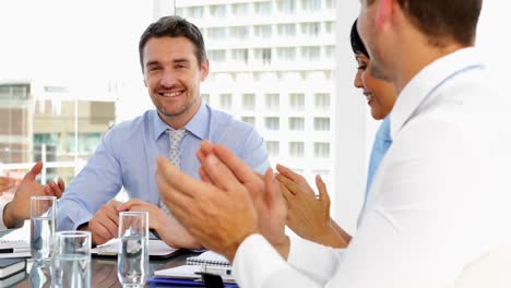 Business-people-applauding-their-boss-during-meeting
