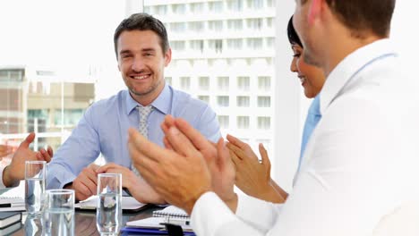 gente de negocios aplaudiendo a su jefe durante la reunión