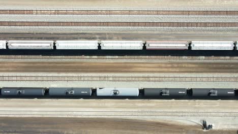 camión con vista de pájaro disparado lateralmente por un dron que volaba sobre la estación de ferrocarril en un entorno desértico en un día soleado con carga y tanques