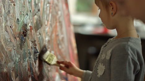 focused children studying in art studio. serious girl painting indoors.