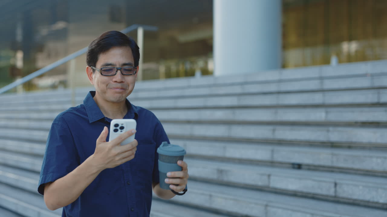 Man using smartphone and drinking coffee on city stairs