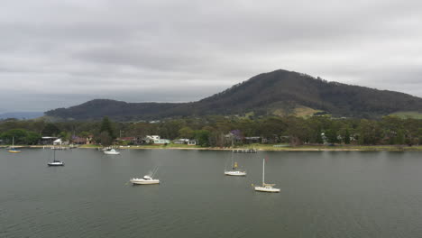 Aerial-drone-shot-around-boats-moored-on-the-Shoalhaven-river,-near-Shoalhaven-heads-on-a-stormy-day-in-south-coast-NSW-Australia