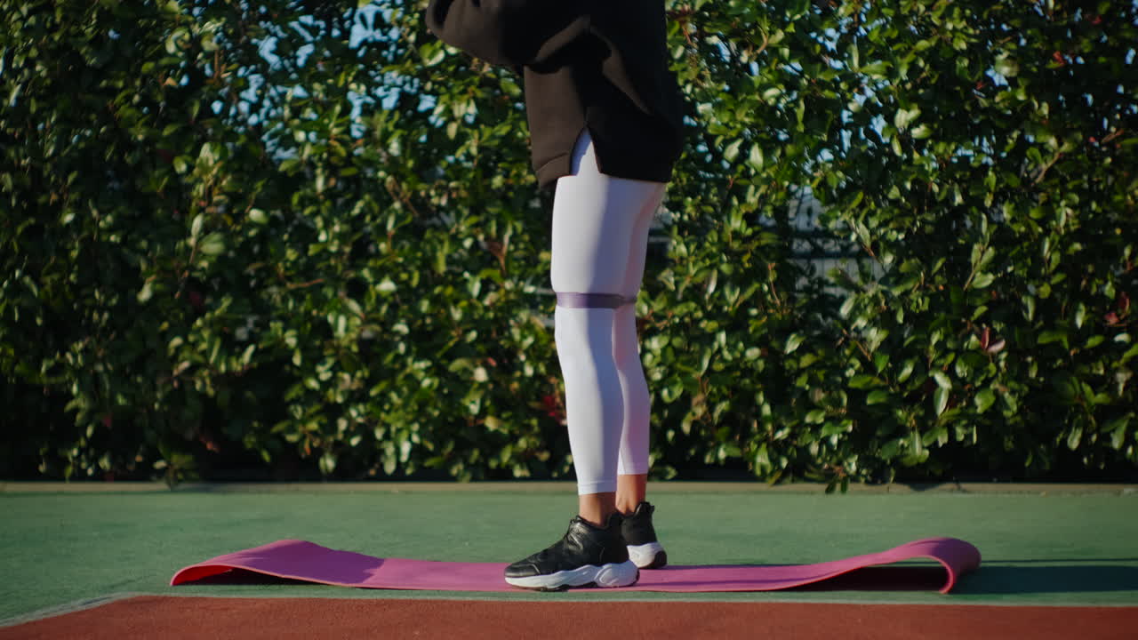 야외에서 저항 밴드와 함께 스을 하는 여성