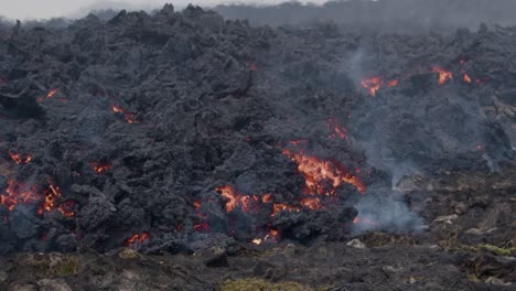 primer plano de lava derretida que fluye lentamente desde el volcán grindavik en el cráter sundhnúkur, islandia