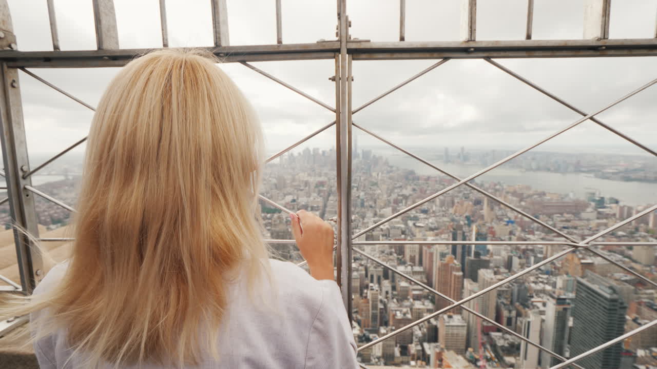 vista trasera de una mujer admirando la ciudad de nueva york desde un punto alto
