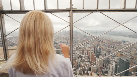 Vista-Trasera-De-Una-Mujer-Admirando-La-Ciudad-De-Nueva-York-Desde-Un-Punto-Alto