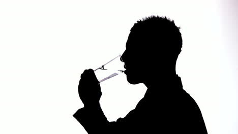 silueta de un hombre de negocios bebiendo agua sobre un fondo blanco