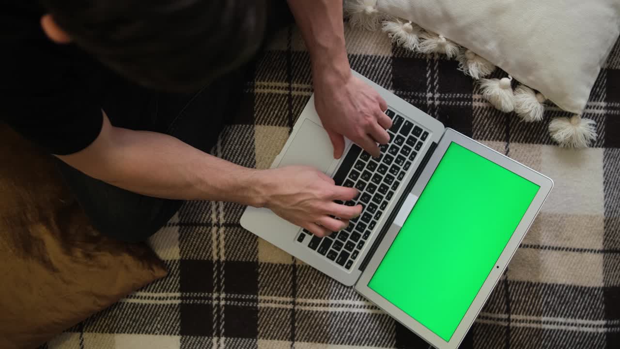 A person works remotely. Green laptop screen. Selective soft focus. The concept of distance education. Surfing the Internet. Top view