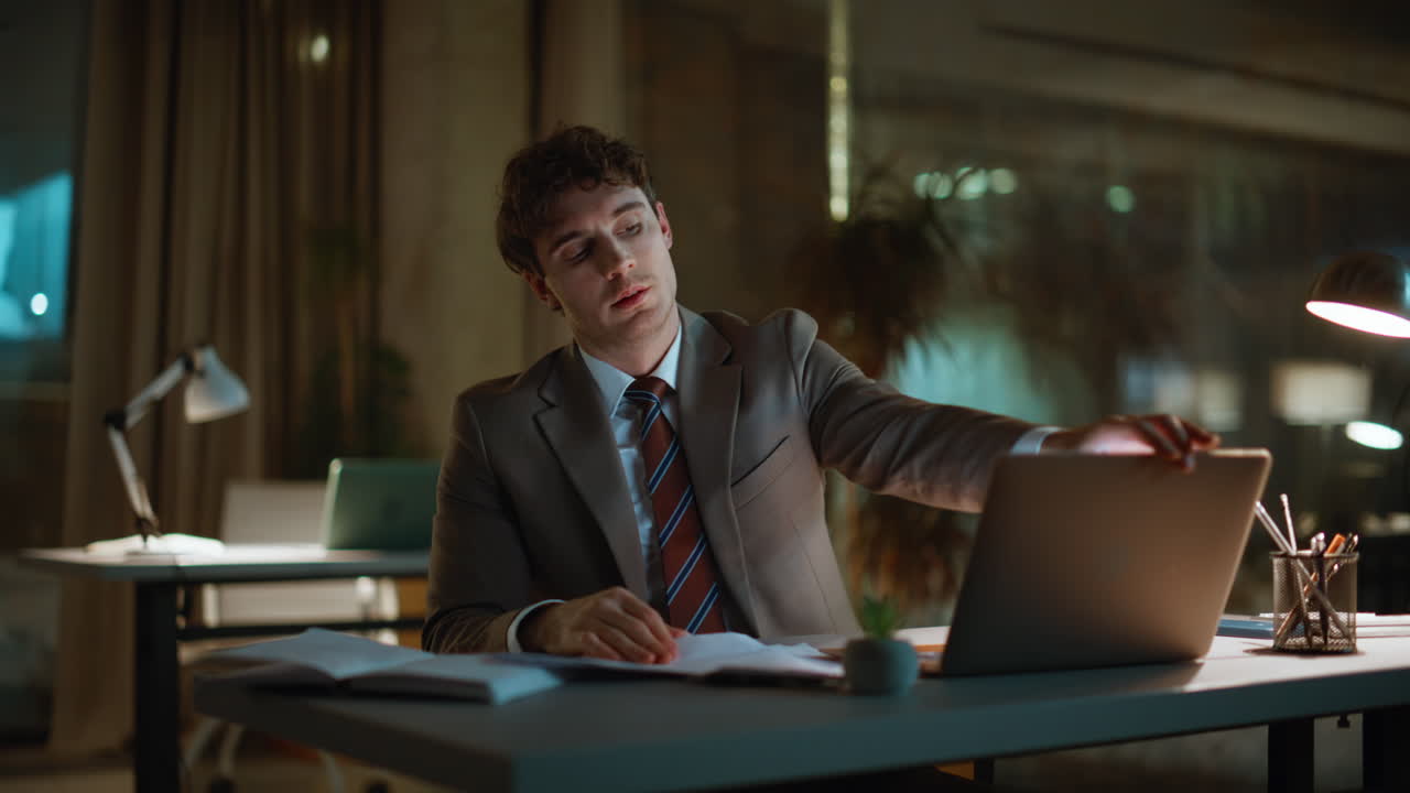 Tired man working overtime sitting dark workspace closeup. Sleepy businessman