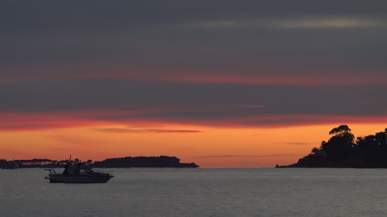 View of a boat floating alone on the sea at sunset