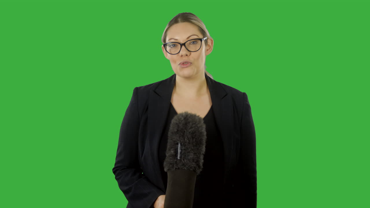 En blond kvinnelig nyhetsreporter hører i ørepluggen sin at hun er direkte på nyhetene