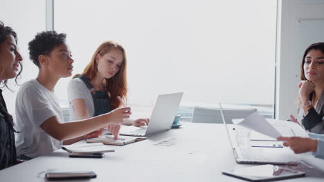 Ein-Team-Junger-Geschäftsfrauen-Trifft-Sich-Am-Tisch-Und-Bespricht-Dokumente-Oder-Pläne-In-Einem-Modernen-Arbeitsbereich