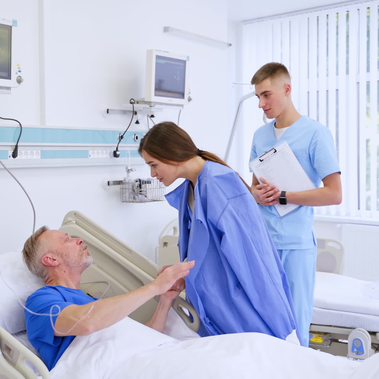 Woman visitor with a patient. Sick father talks to her daughter in clinic. Senior patient laying in hospital bed and talking to a young woman.