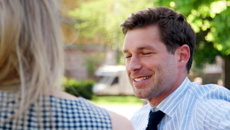 businessman talking to female colleague on break in park