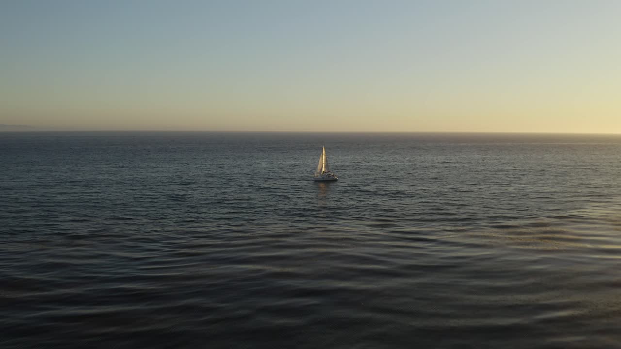 무인 항공기는 바다에서 혼자 요트 위를 날아, 새의 눈 일몰보기