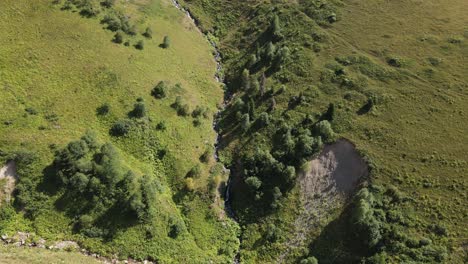 Drone-view-of-water-flowing-through-hills-in-the-Black-Sea,-green-lands,-Turkey