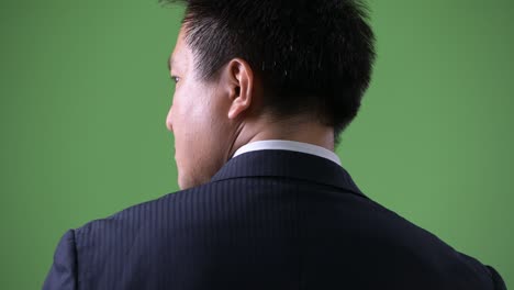 mature japanese businessman against green background