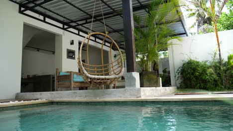 open air bali villa with a pool and ceiling swing swaying in the breeze