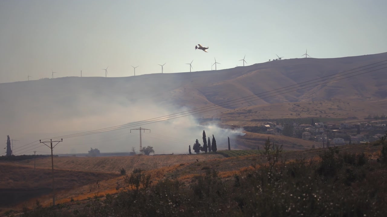 Velivolo che vola sopra la valle in fiamme.