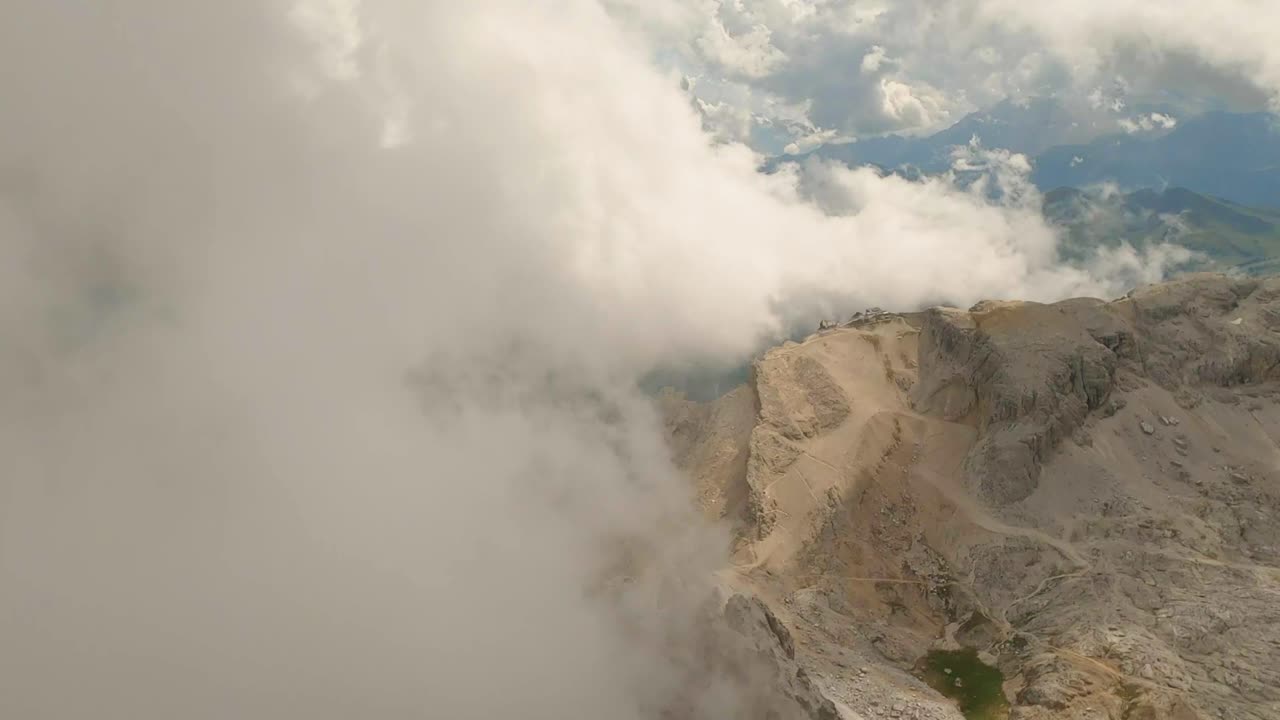 descendiendo a través de las nubes, el dron sobrepasa la montaña lagazuoi, las dolomitas italianas, para un emocionante descenso alpino, casi pastando el pico escarpado