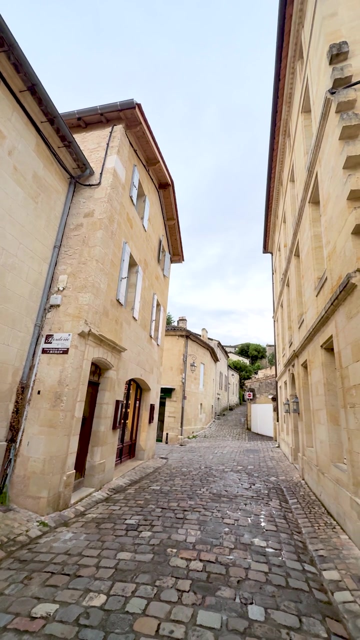 Panoramica lenta a destra di una strada stretta acciottolata in una città storica europea