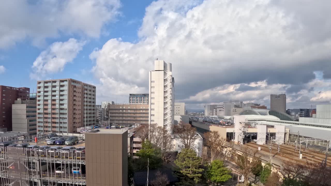 A wide angle timelapse captures moving clouds over the Kanazawa cityscape and train station area