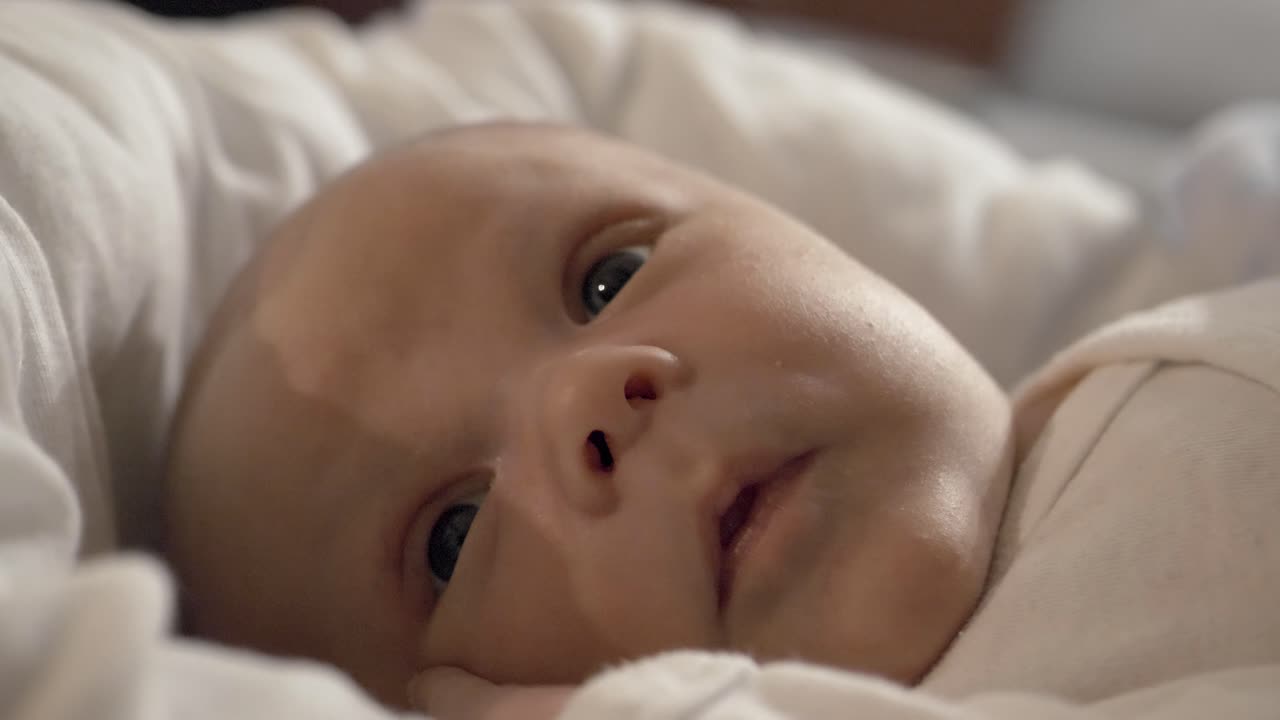 Adorable beautiful newborn baby boy lying in cot