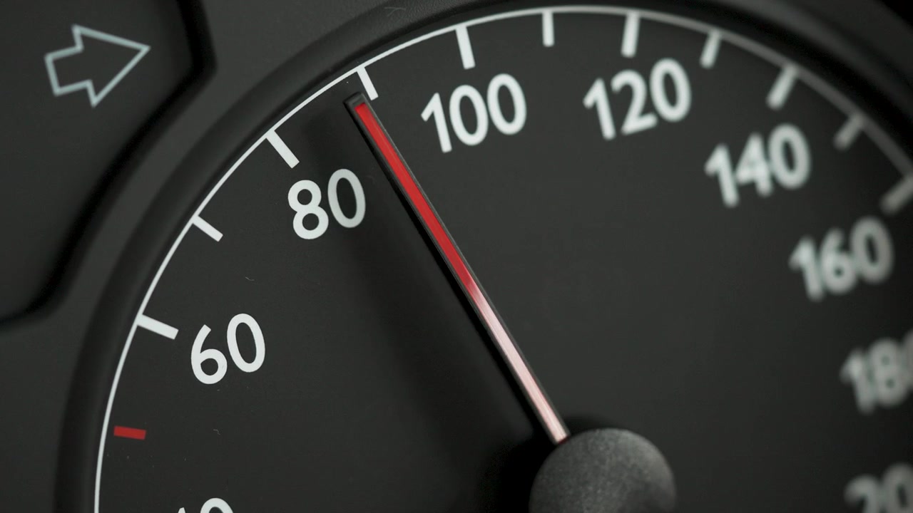 Close-up of a car speedometer with a red needle moving from 60 to 80 kmh. Concept image for acceleration, increasing speed, driving dynamics, traffic, road safety, and transportation.