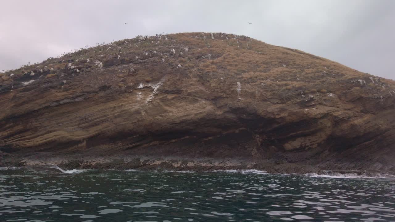 Gimbal close-up panning shot of Molokini Crater with seabirds nesting along the rocky cliffs in South Maui, Hawai'i