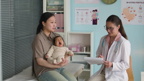 mother and baby with doctor in clinic