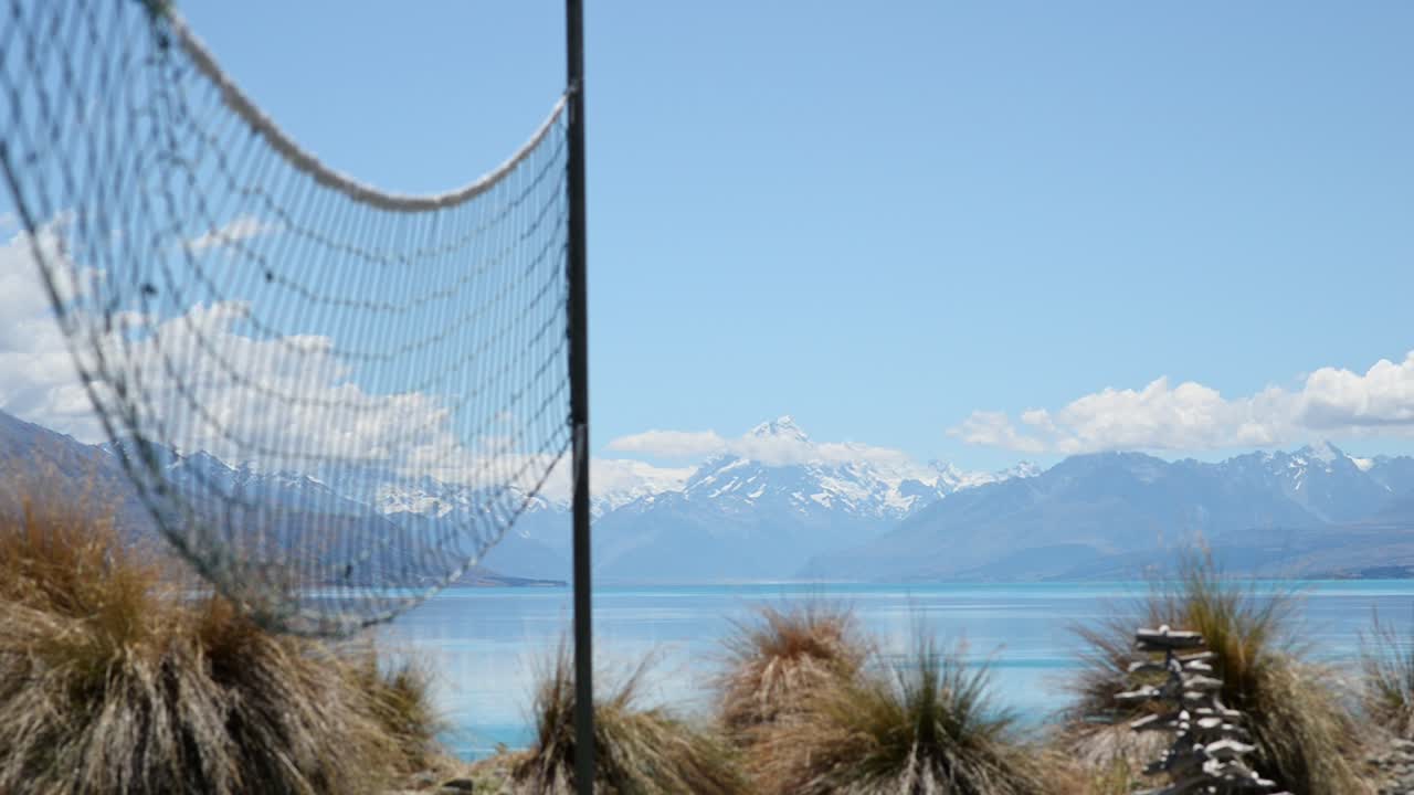 red de voleibol moviéndose en el viento con el impresionante monte cook y el lago pukaki en segundo plano
