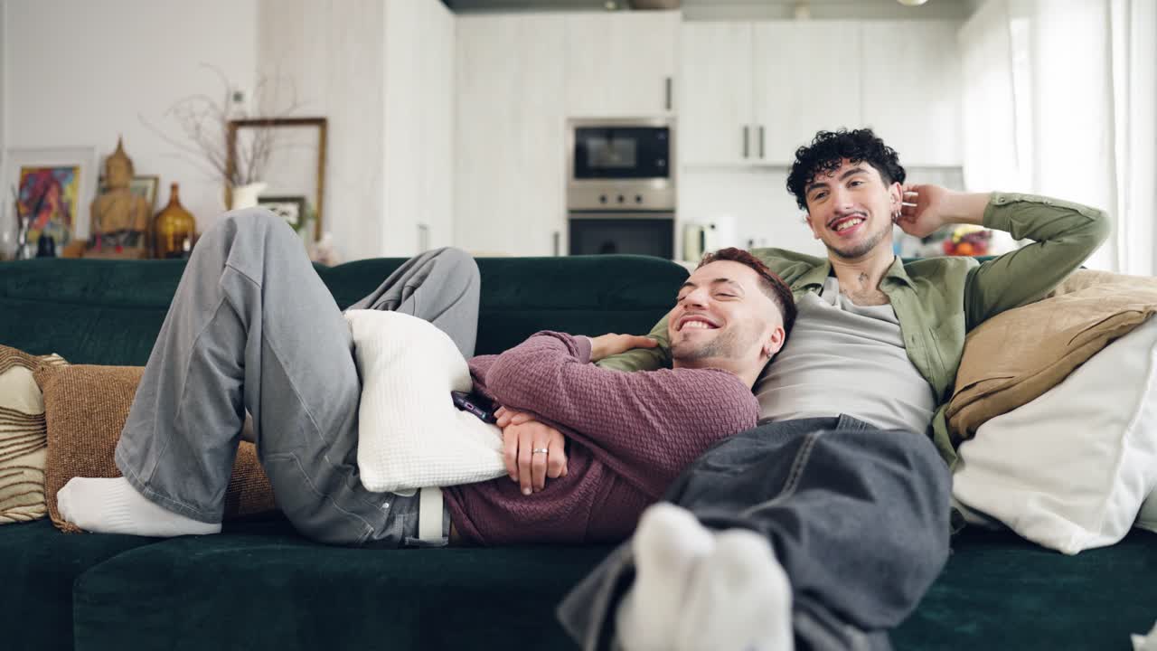Giovane Coppia Gay che si Rilassa sul Divano a Casa con una Borsa dell'Acqua Calda